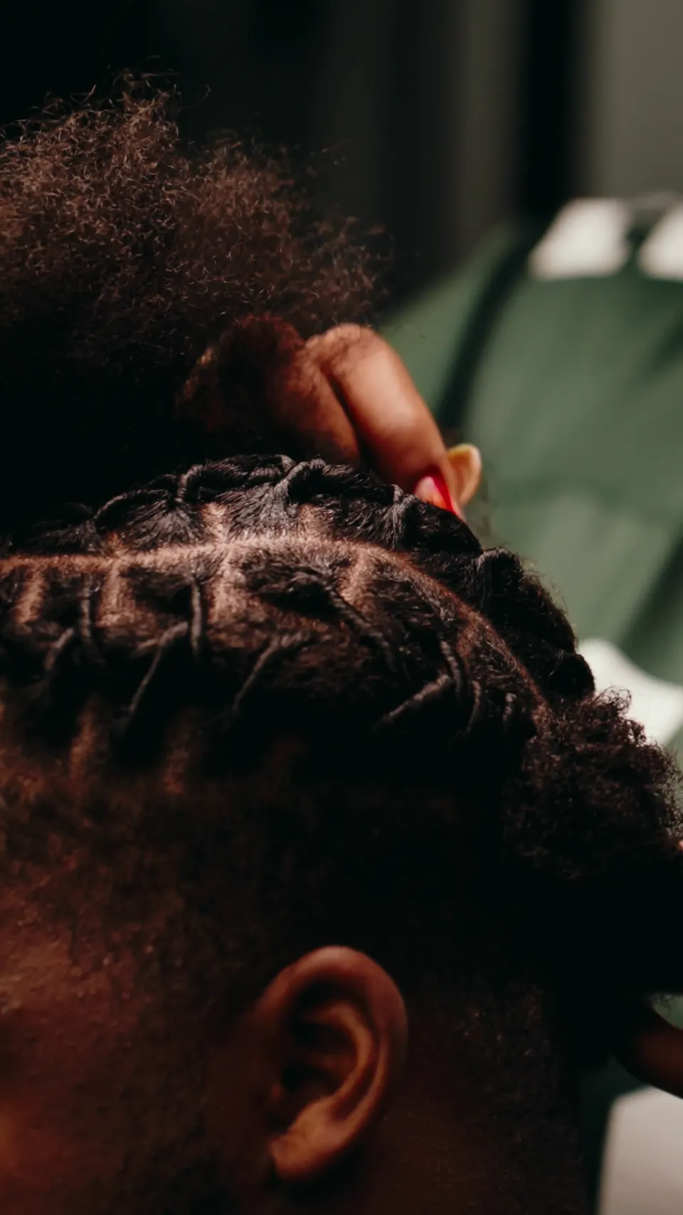 Close-up of cornrows being parted and braided