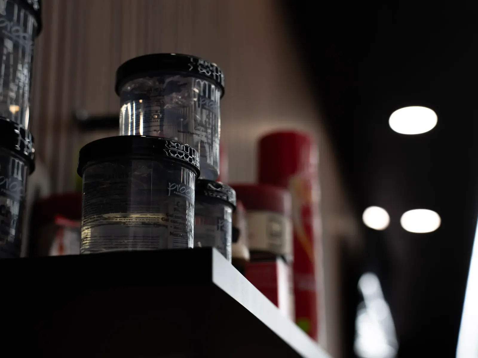 Product jars on a shelf under spot lights