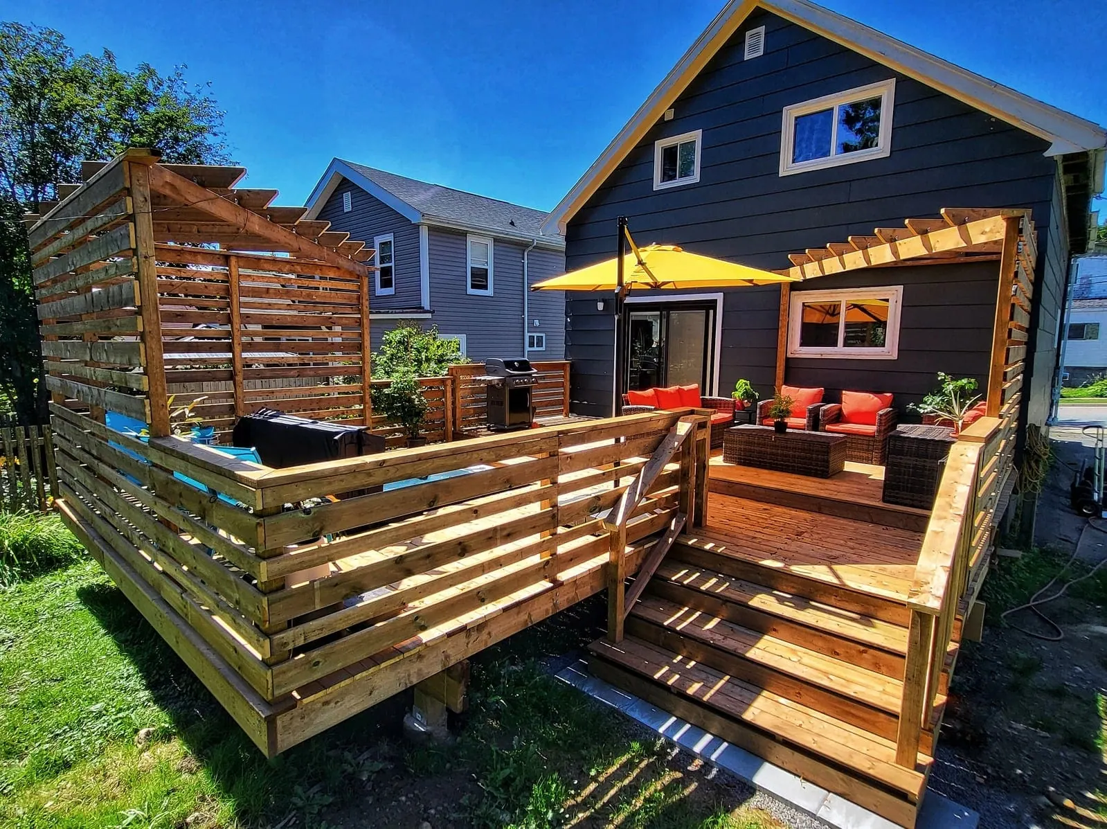 Back yard after: two-level wood deck with privacy screens and a pergola