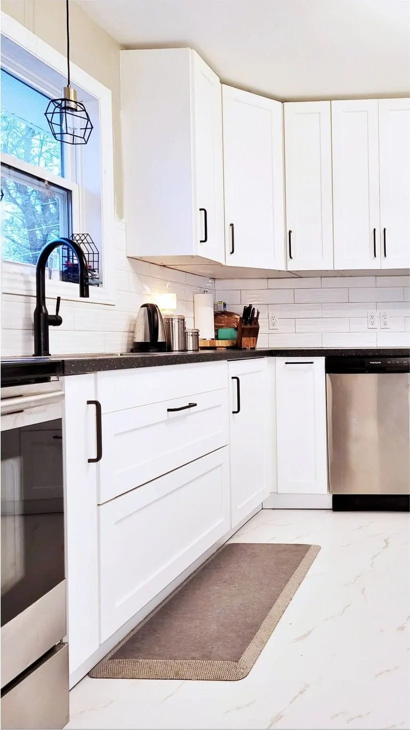 Narrow white IKEA kitchen with a runner rug