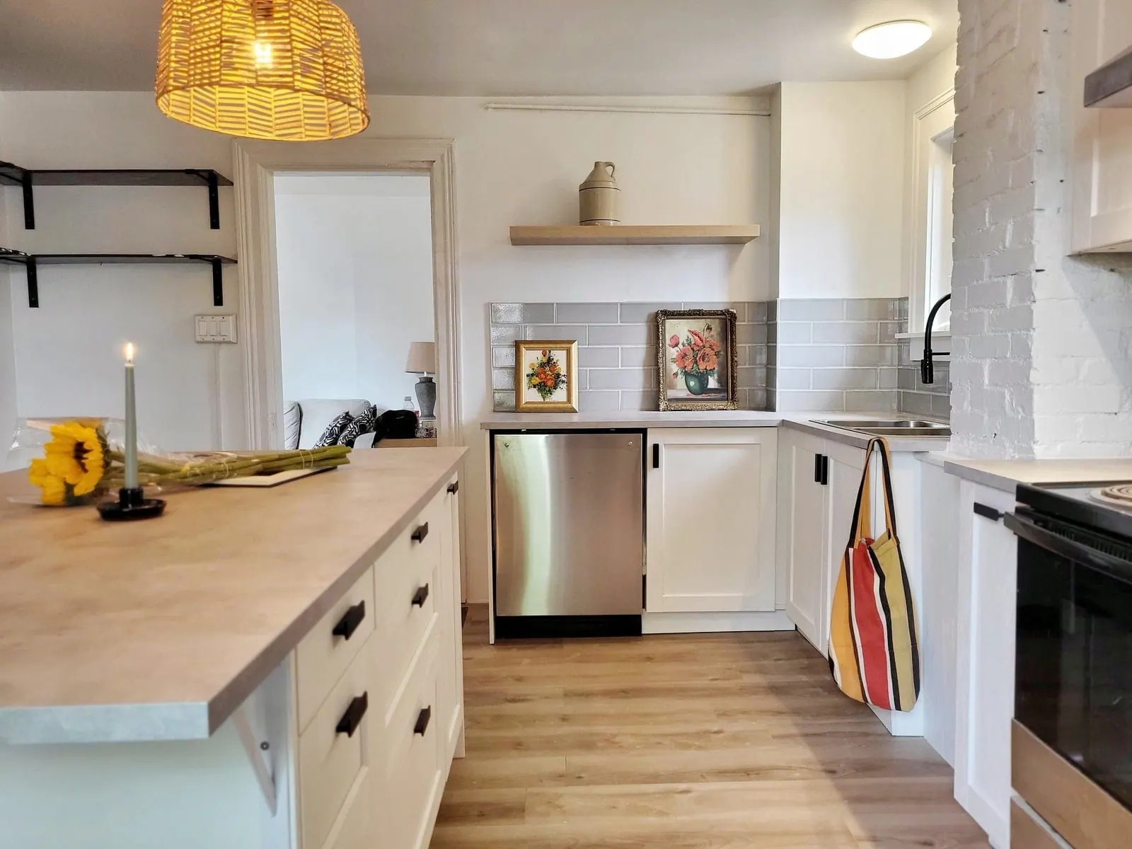 Finished IKEA kitchen with an island, open shelving and a woven pendant light