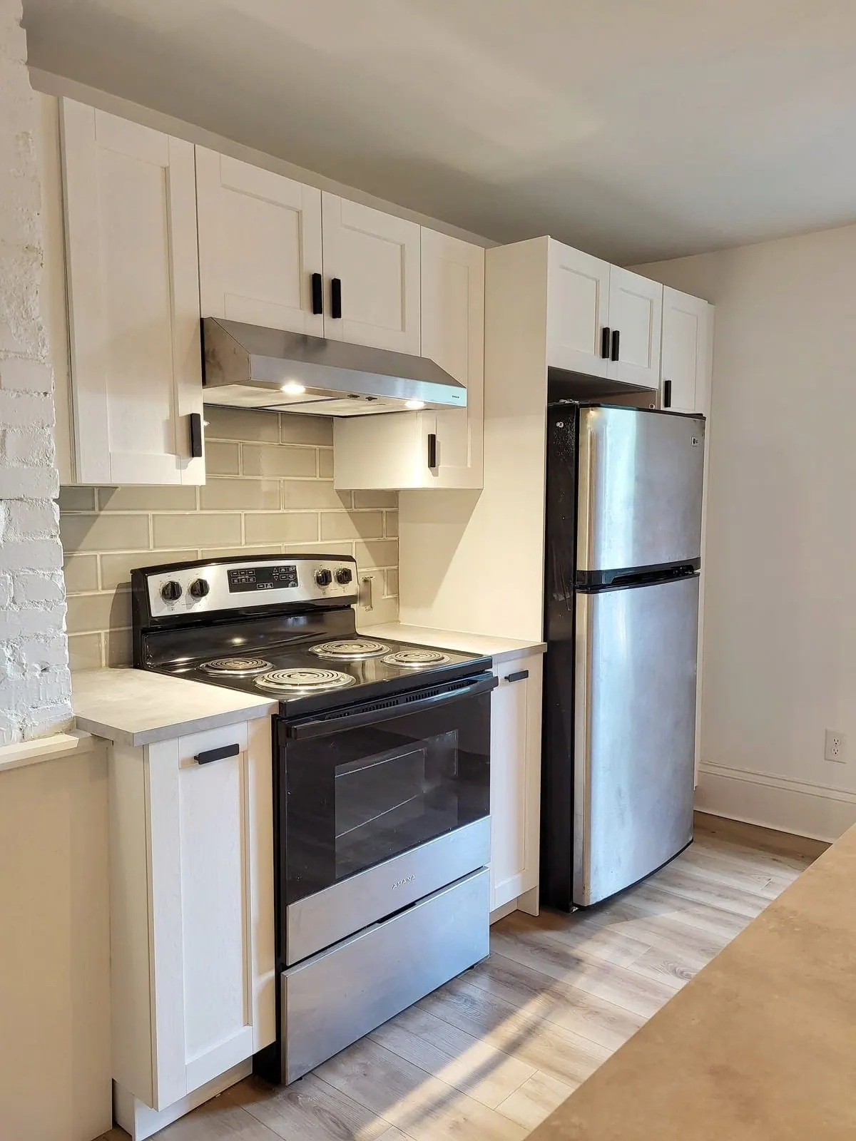 IKEA kitchen with grey subway tile, a stainless range and fridge