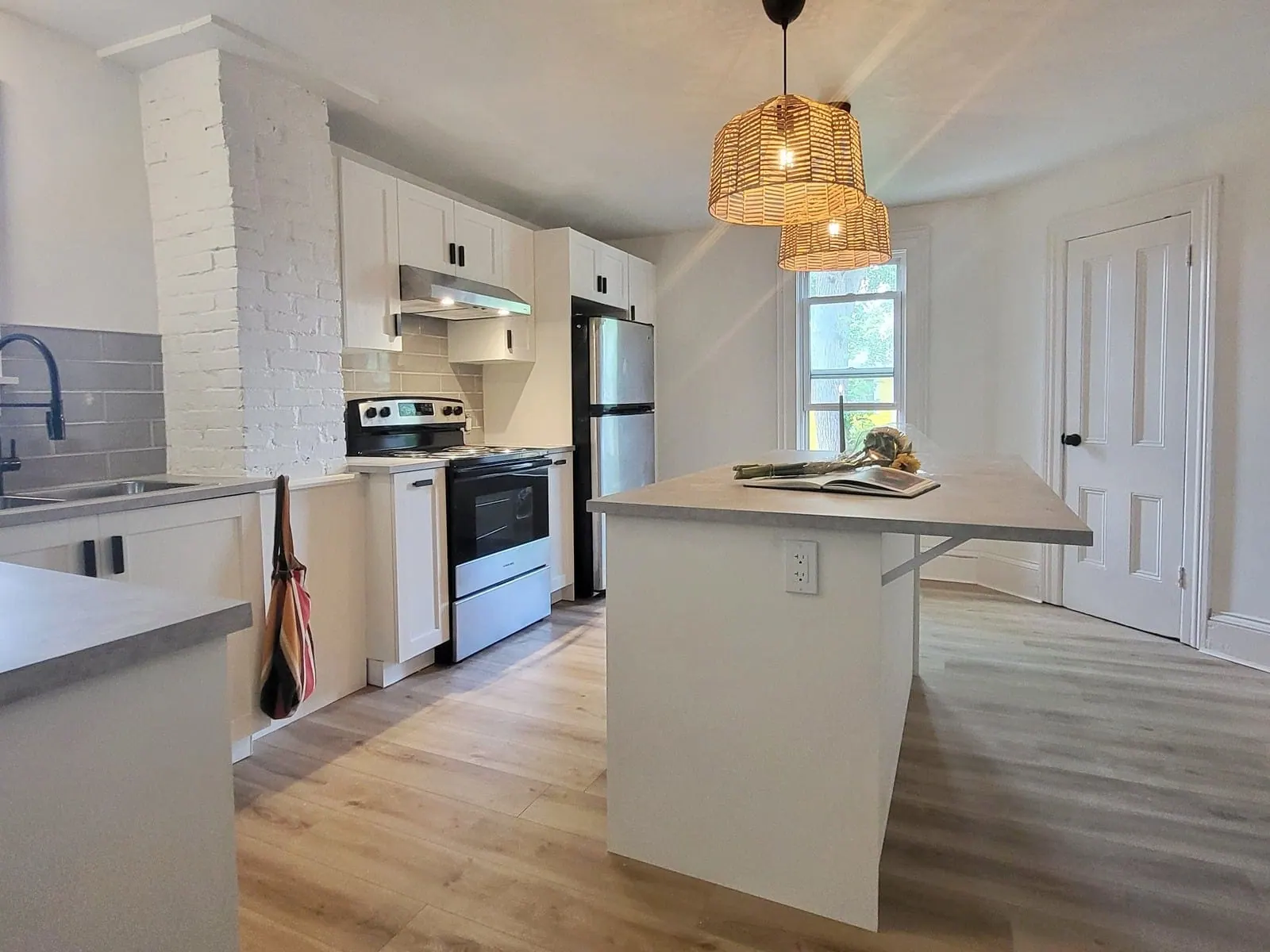 IKEA kitchen with a white island, open shelving and a woven pendant light