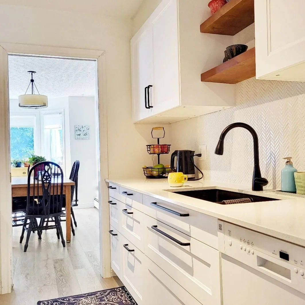 IKEA kitchen with a black faucet and a window over the sink