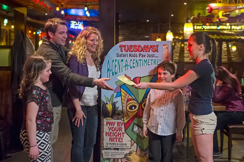 Family at a Jungle Jim's promotion board