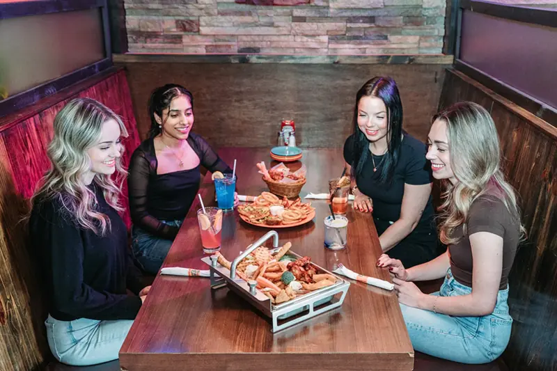 Friends sharing platters in a booth