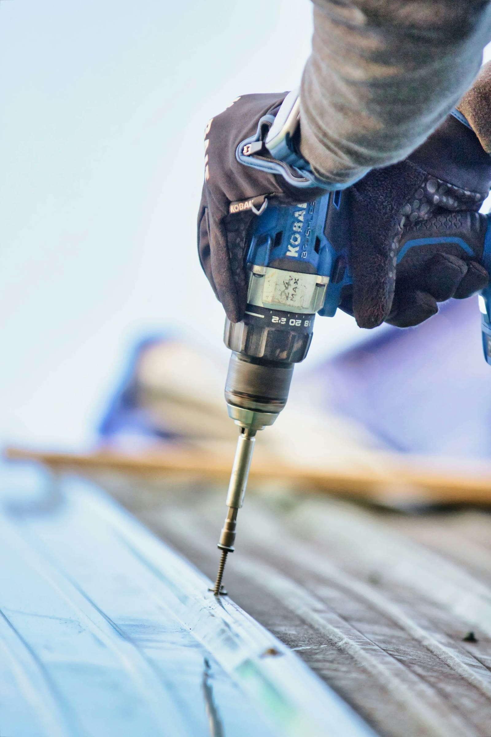 Roofer fastening a metal roof panel