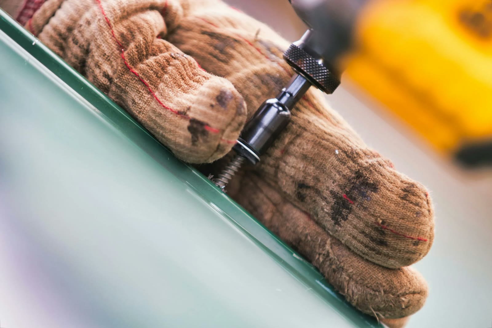 Roofer's gloved hands at work on a roof
