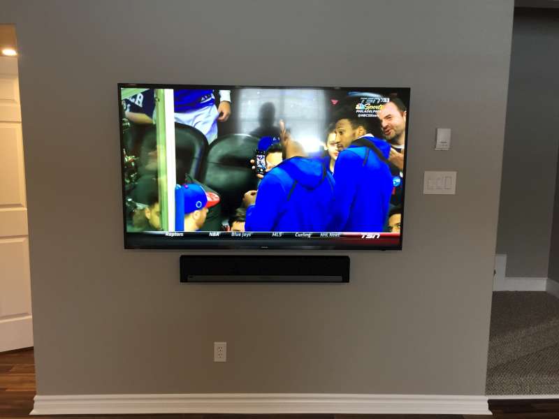 Wall-mounted TV with a Sonos soundbar below it, no visible cables