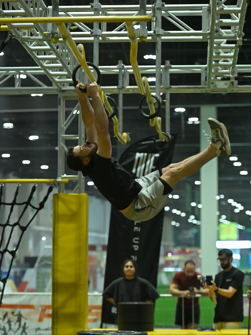 A competitor swinging through the ninja course
