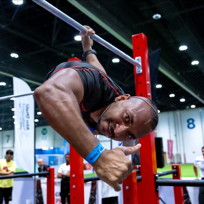 A competitor giving a thumbs-up mid-set on the bar rig