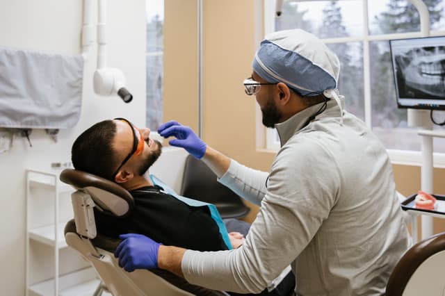 Dr. Ali examining a patient in a treatment room at Ravines Dental Centre