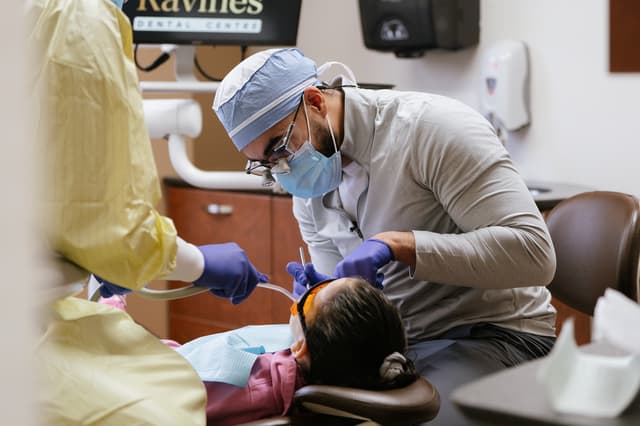 Dr. Ali treating a patient alongside a dental assistant