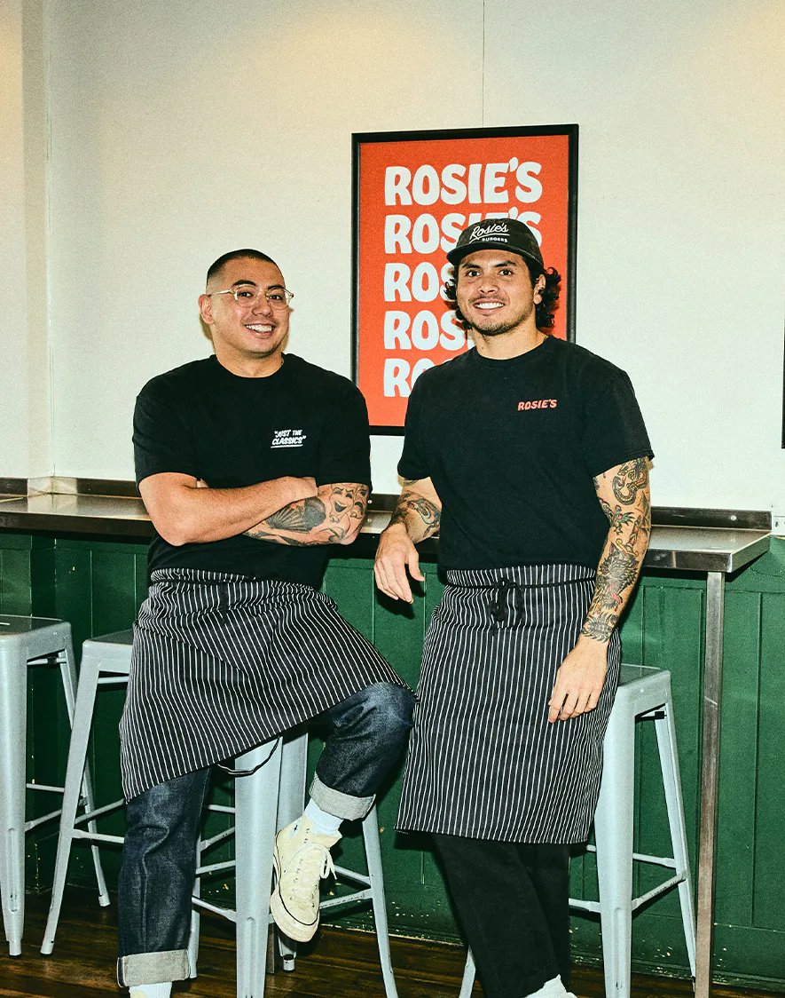 Two Rosie's crew members in aprons at the counter