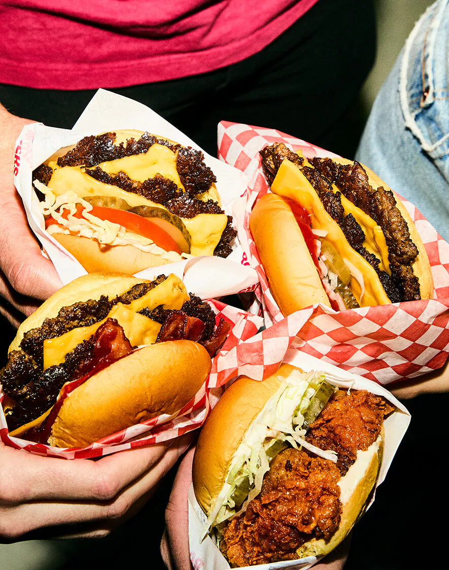 Three Rosie's double smashburgers stacked, cheese melting over the patties