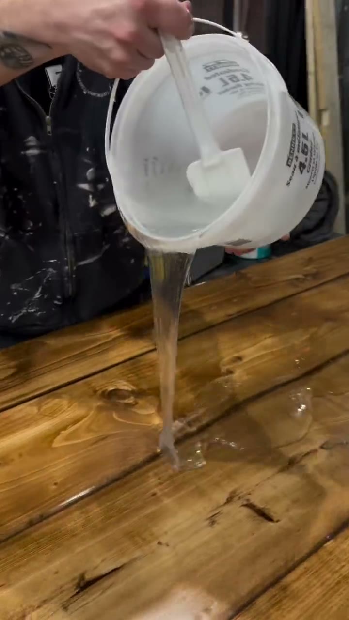 Finish being poured over a wooden tabletop